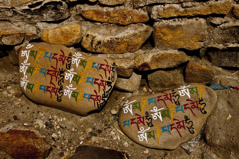 Sacred Tibetan religious text scripted in stones, a common Tibetan Buddhism practice.
