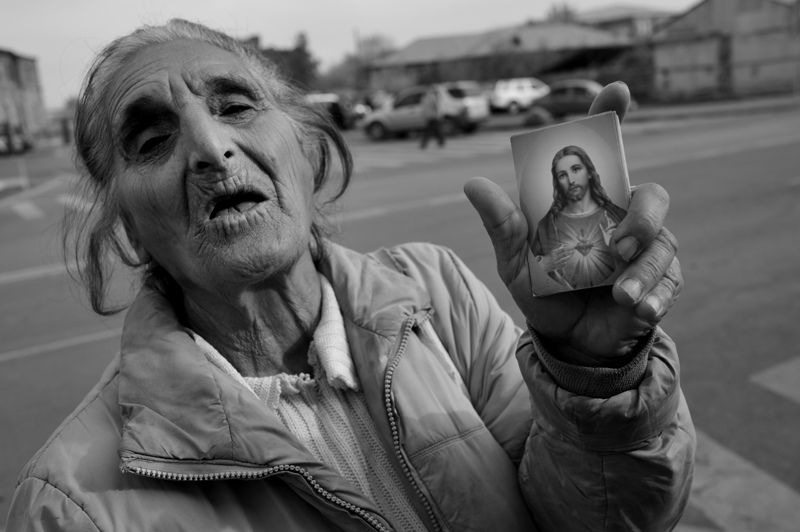 Woman sells a postcard of the Christ outside the Mother See of Holy Etchmiadzin, the world's oldest national church